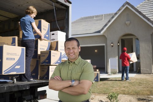 Moving truck and crew handling furniture near a Dulwich home