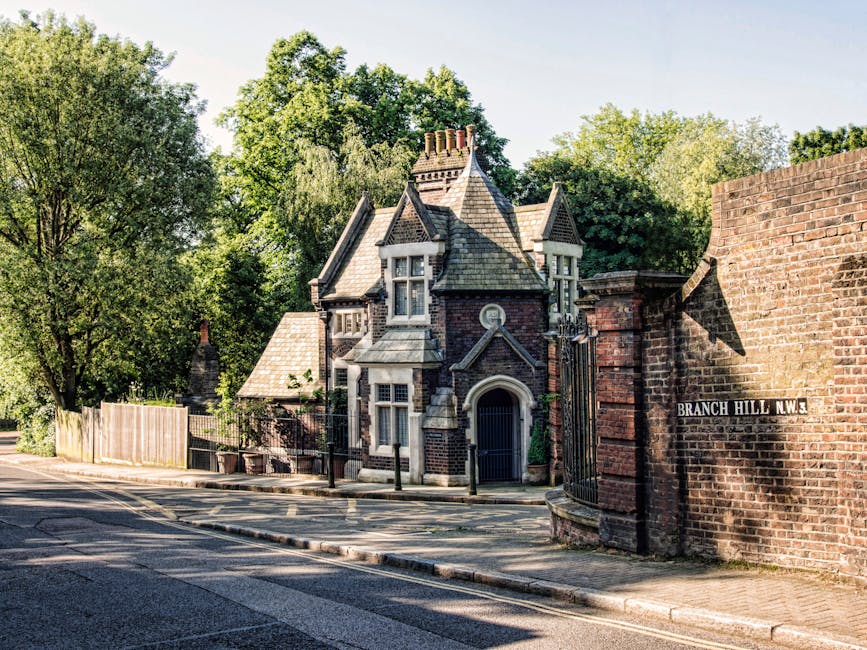 A Victorian-style house situated on a quiet residential street near Dulwich Village, featuring dark brickwork and ornate architectural details. The property is partially visible behind a black wrought
